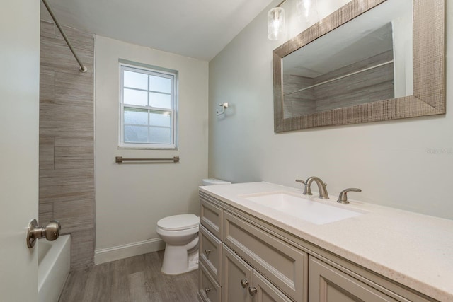 10137 Oleander Dr, Port Richey, FL 34668 - bathroom featuring vanity, toilet, wood finished floors, bathtub / shower combination, and baseboards