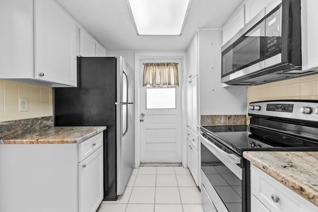 500 Glennes Ln Unit 205, Dunedin, FL 34698 - kitchen featuring backsplash, white cabinetry, stainless steel appliances, and light tile patterned floors