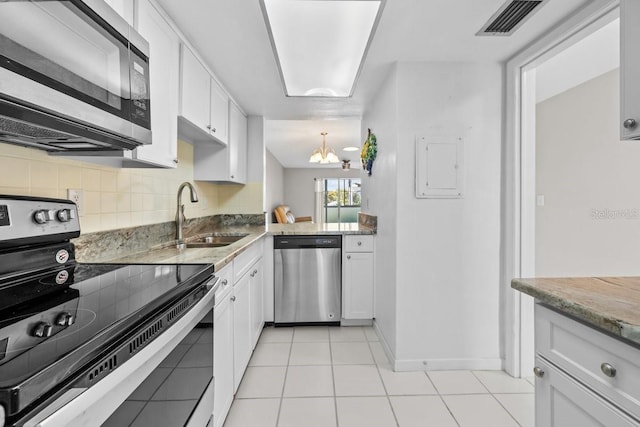 500 Glennes Ln Unit 205, Dunedin, FL 34698 - kitchen featuring a sink, visible vents, an inviting chandelier, white cabinetry, and appliances with stainless steel finishes