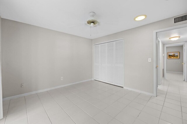 500 Glennes Ln Unit 205, Dunedin, FL 34698 - unfurnished bedroom with a ceiling fan, a closet, light tile patterned floors, baseboards, and visible vents
