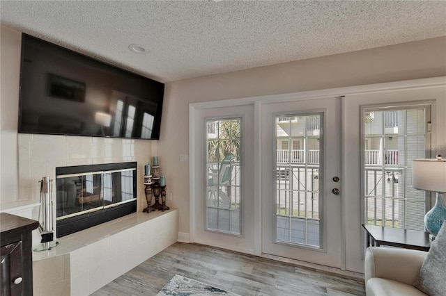 17960 Gulf Blvd Unit 111, Redington Shores, FL 33708 - doorway with a textured ceiling, a tiled fireplace, and wood finished floors