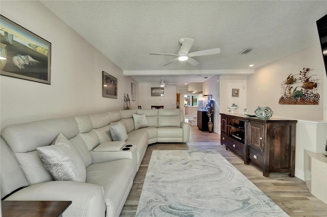 17960 Gulf Blvd Unit 111, Redington Shores, FL 33708 - living room featuring a textured ceiling, a ceiling fan, and light wood-style flooring