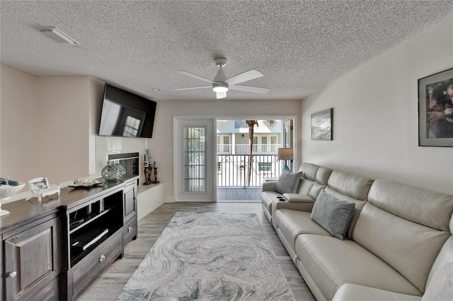 17960 Gulf Blvd Unit 111, Redington Shores, FL 33708 - living area featuring visible vents, a textured ceiling, ceiling fan, and light wood-type flooring