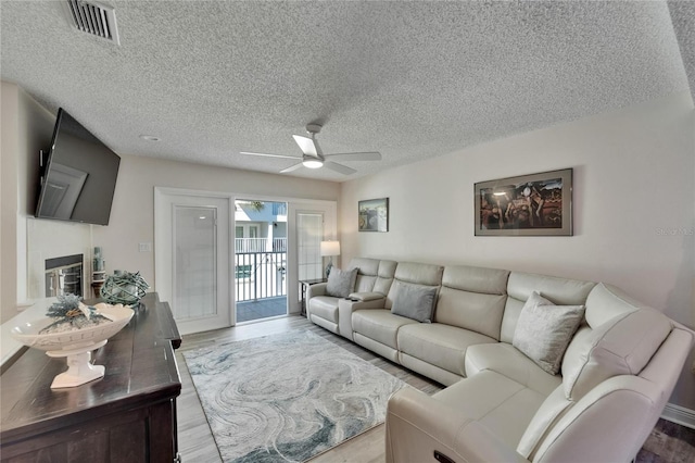 17960 Gulf Blvd Unit 111, Redington Shores, FL 33708 - living area with a textured ceiling, ceiling fan, visible vents, and wood finished floors