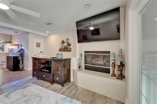 17960 Gulf Blvd Unit 111, Redington Shores, FL 33708 - living area with a glass covered fireplace, a ceiling fan, wood finished floors, and visible vents