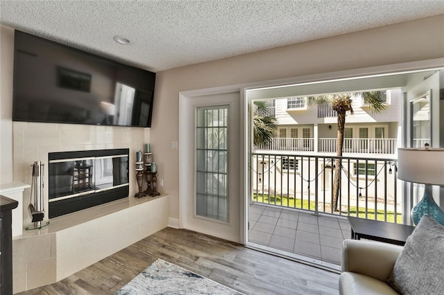 17960 Gulf Blvd Unit 111, Redington Shores, FL 33708 - doorway to outside featuring a textured ceiling, wood finished floors, and a tile fireplace