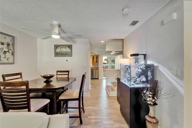 17960 Gulf Blvd Unit 111, Redington Shores, FL 33708 - dining room with light wood-style floors, a ceiling fan, a textured ceiling, and visible vents