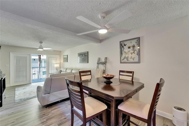 17960 Gulf Blvd Unit 111, Redington Shores, FL 33708 - dining room featuring baseboards, ceiling fan, light wood-type flooring, and a textured ceiling