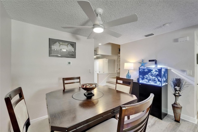 17960 Gulf Blvd Unit 111, Redington Shores, FL 33708 - dining room with a textured ceiling, ceiling fan, baseboards, and light wood-style floors