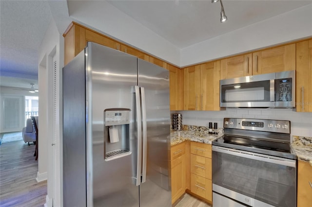 17960 Gulf Blvd Unit 111, Redington Shores, FL 33708 - kitchen featuring light stone counters, tasteful backsplash, stainless steel appliances, and light wood finished floors