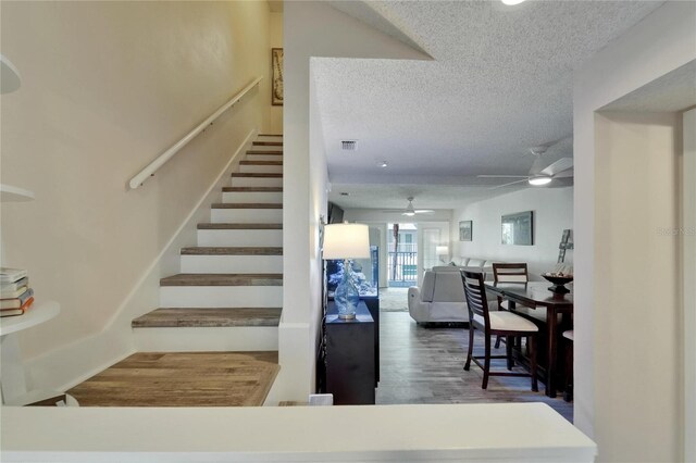 17960 Gulf Blvd Unit 111, Redington Shores, FL 33708 - stairs featuring visible vents, a ceiling fan, a textured ceiling, and wood finished floors