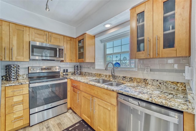 17960 Gulf Blvd Unit 111, Redington Shores, FL 33708 - kitchen featuring appliances with stainless steel finishes, tasteful backsplash, a sink, and light stone counters