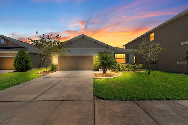 ranch-style home with a garage, stucco siding, a yard, and driveway