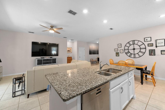 kitchen with stainless steel dishwasher, light tile patterned floors, visible vents, and a sink