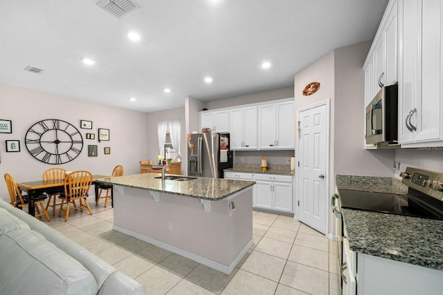 kitchen with a kitchen island with sink, a breakfast bar area, visible vents, stainless steel appliances, and white cabinetry