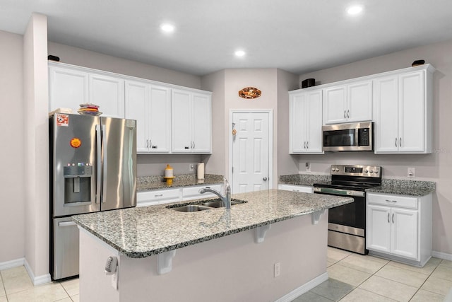kitchen with baseboards, a sink, white cabinetry, and appliances with stainless steel finishes