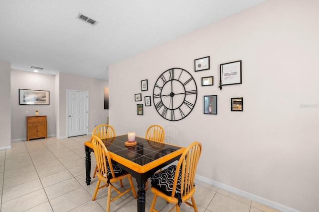 dining area featuring light tile patterned floors, baseboards, and visible vents