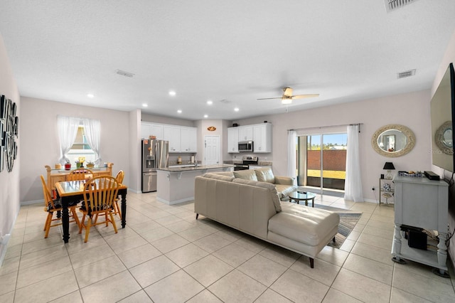 living room with a ceiling fan, baseboards, recessed lighting, light tile patterned floors, and visible vents