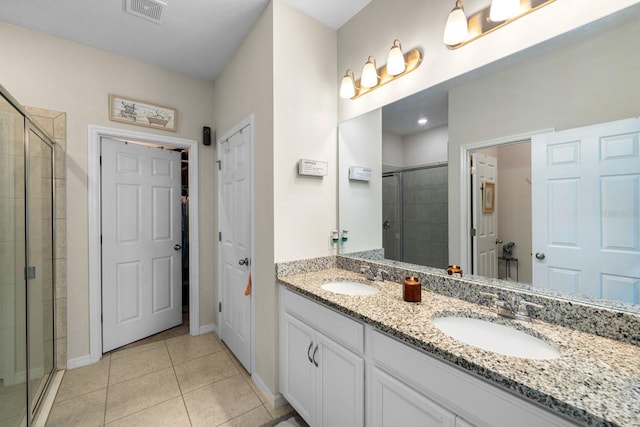 full bathroom featuring a sink, a stall shower, and visible vents