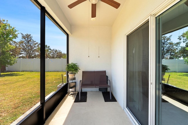 unfurnished sunroom with ceiling fan