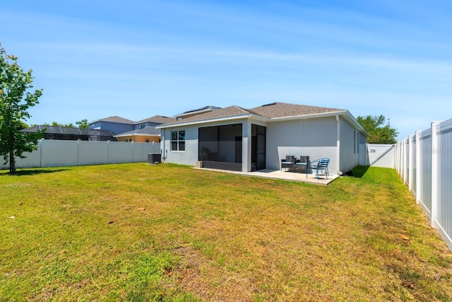 rear view of house featuring a lawn, a fenced backyard, a patio area, and stucco siding