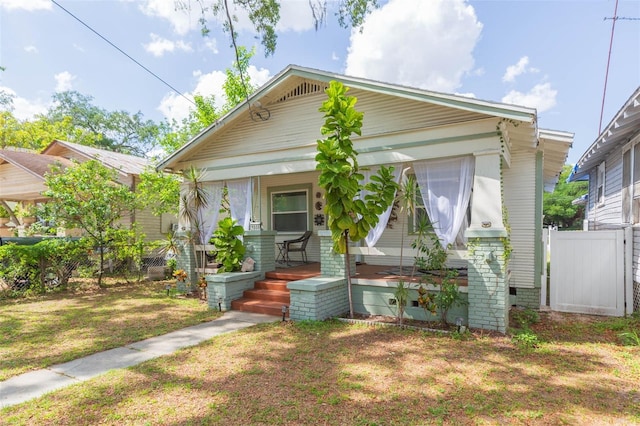 1008 E 25th Ave, Tampa, FL 33605 - view of front facade with fence, a front yard, and covered porch