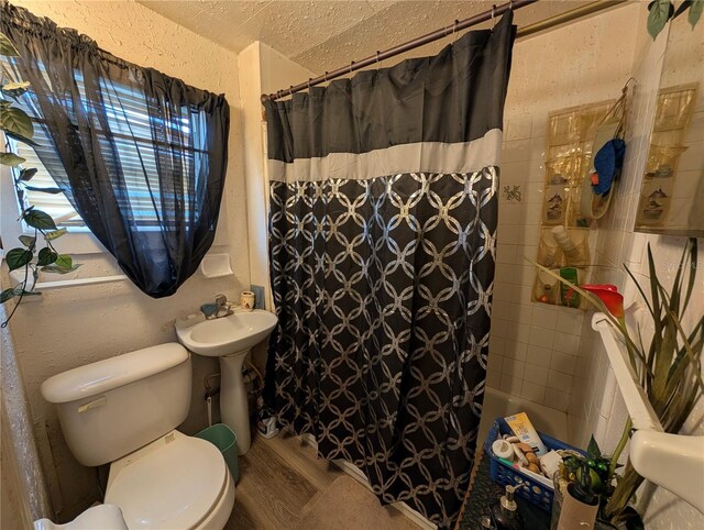 730 Citrus St, Orlando, FL 32805 - full bathroom with wood finished floors, toilet, a textured ceiling, shower / tub combo, and a sink
