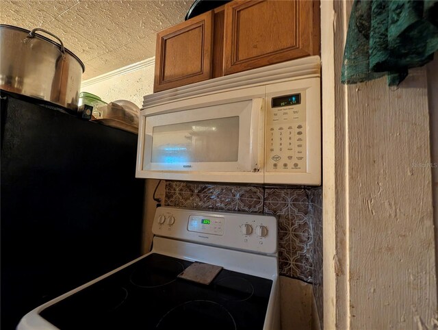 730 Citrus St, Orlando, FL 32805 - kitchen view of white appliances, brown cabinets, and decorative backsplash