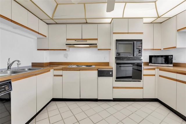 4450 Gulf Blvd Unit 114, St Pete Beach, FL 33706 - kitchen with black appliances, under cabinet range hood, and white cabinetry