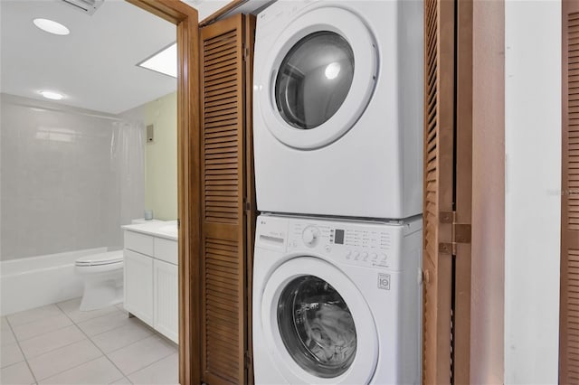 4450 Gulf Blvd Unit 114, St Pete Beach, FL 33706 - laundry area with stacked washer and clothes dryer and light tile patterned flooring