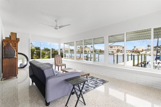 sunroom / solarium featuring speckled floor and a water view