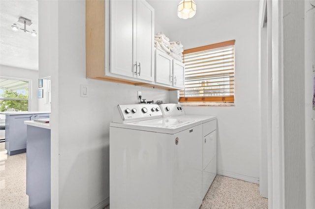 laundry room featuring separate washer and dryer and cabinet space