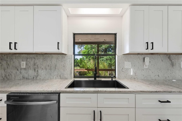 kitchen with white cabinets, tasteful backsplash, light stone countertops, and stainless steel dishwasher