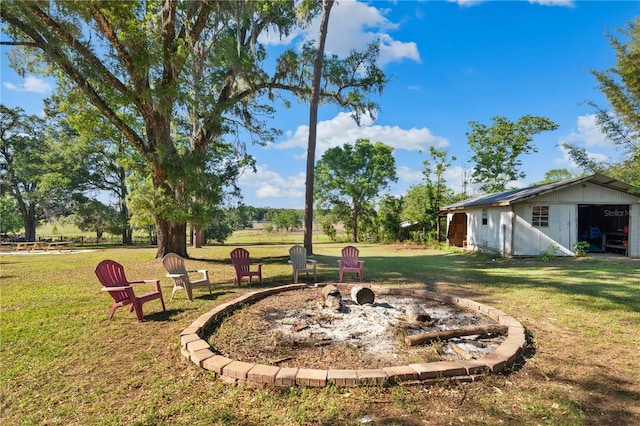 view of yard with a fire pit and an outdoor structure