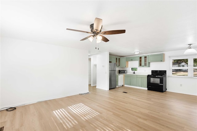 unfurnished living room featuring visible vents, a ceiling fan, baseboards, and light wood-style floors
