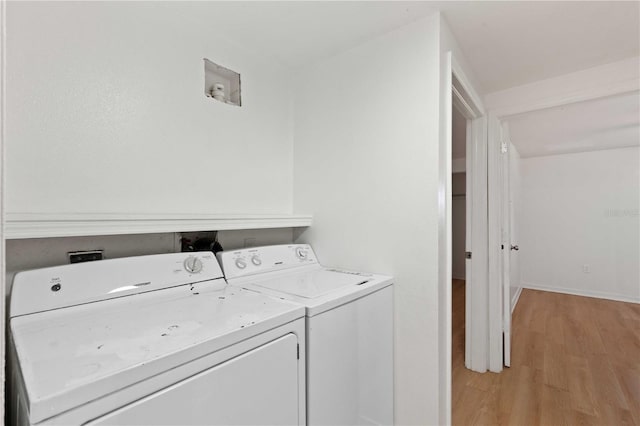 laundry area with separate washer and dryer, laundry area, and light wood-style floors