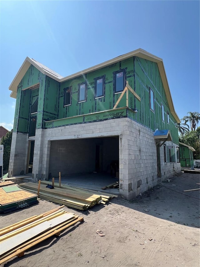 view of front facade featuring a garage and concrete block siding