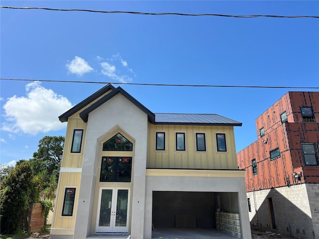 812 W Braddock St, Tampa, FL 33603 - view of front of home featuring french doors, board and batten siding, driveway, an attached garage, and stucco siding