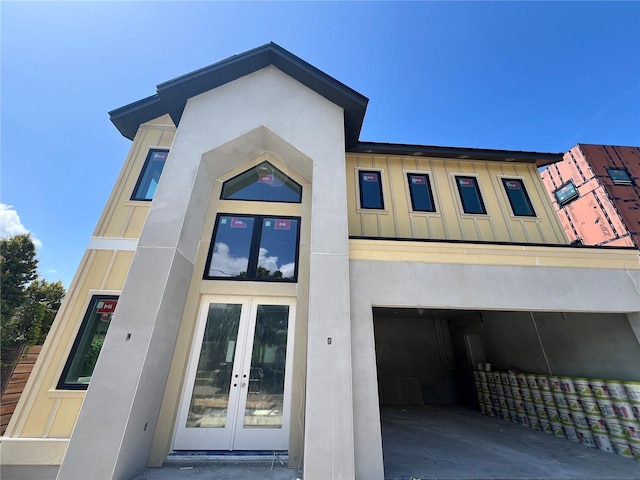 812 W Braddock St, Tampa, FL 33603 - view of front facade featuring french doors, stucco siding, board and batten siding, and an attached garage
