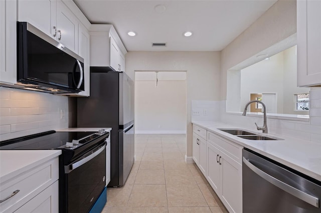 233 45th Ave, St Pete Beach, FL 33706 - kitchen with stainless steel appliances, light countertops, backsplash, white cabinetry, and recessed lighting