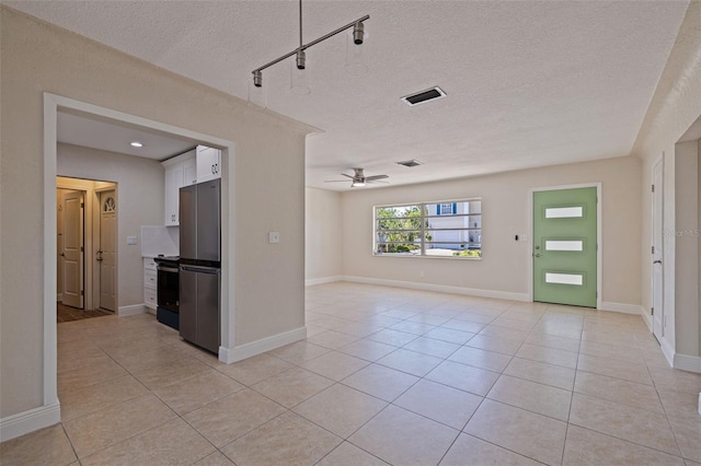 233 45th Ave, St Pete Beach, FL 33706 - unfurnished living room featuring light tile patterned floors, ceiling fan, and a textured ceiling