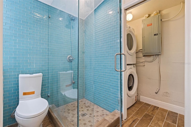 233 45th Ave, St Pete Beach, FL 33706 - full bathroom with electric panel, stacked washer and clothes dryer, a stall shower, and wood tiled floors