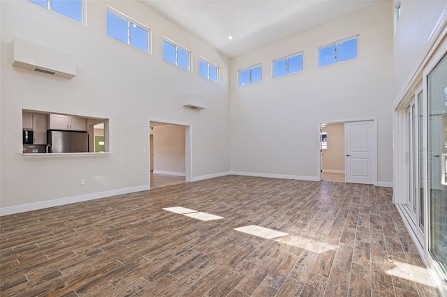 233 45th Ave, St Pete Beach, FL 33706 - unfurnished living room with wood finished floors and a high ceiling