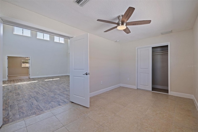 233 45th Ave, St Pete Beach, FL 33706 - unfurnished bedroom with light tile patterned floors, a ceiling fan, a closet, and a textured ceiling