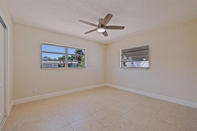 233 45th Ave, St Pete Beach, FL 33706 - tiled empty room with plenty of natural light, a ceiling fan, and a textured ceiling