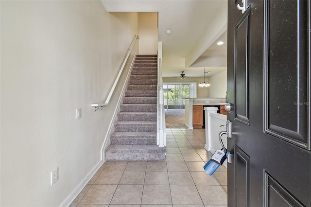 foyer entrance with baseboards, stairs, and light tile patterned flooring