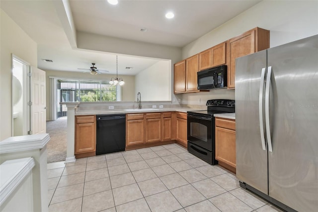 kitchen featuring a peninsula, a sink, visible vents, light countertops, and black appliances