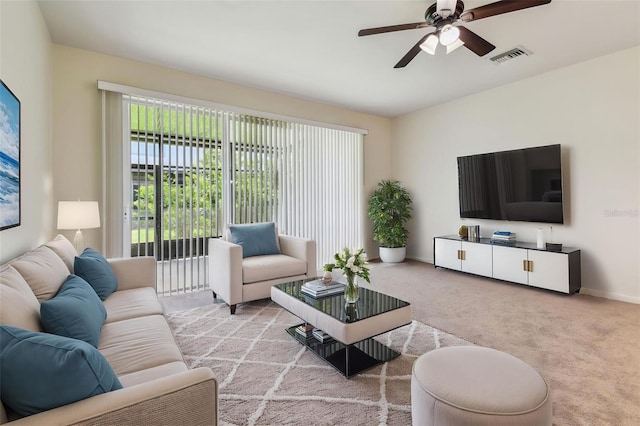 living room with baseboards, a ceiling fan, visible vents, and carpet