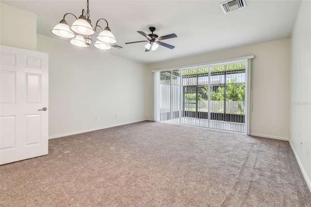 carpeted spare room featuring ceiling fan with notable chandelier, baseboards, and visible vents