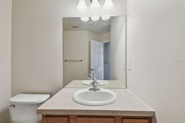 bathroom with visible vents, vanity, and toilet